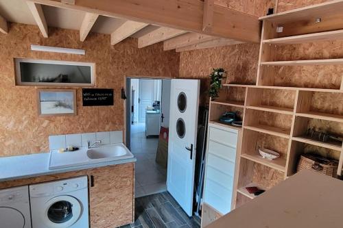 une cuisine avec un évier et un réfrigérateur dans l'établissement Gîte de bord de mer, Le Calicoco, à Gatteville-le-Phare