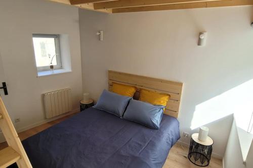 - une chambre avec un lit doté de draps bleus et d'oreillers jaunes dans l'établissement Gîte de bord de mer, Le Calicoco, à Gatteville-le-Phare