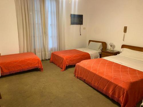 Una habitación de hotel con dos camas y un televisor. en Hotel guido palace, en Buenos Aires