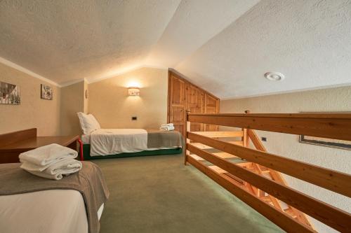 a room with two beds and a wooden railing at Hotel Walser Courmayeur in Courmayeur