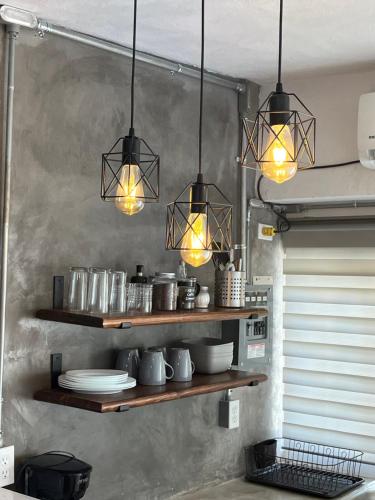 a kitchen with three lights hanging from a wall at A pasos del mercado y centro histórico, diseño industrial in San José del Cabo