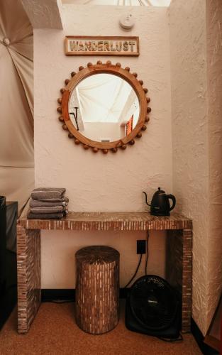 a mirror on a wall with a table and a basket at DayDreamer Domes in South Haven