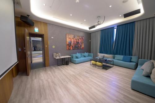 a living room with blue couches and a table at 宜蘭頭城A Happy Birthday 私人溫泉 海景 蘭陽夜景大陽台無邊際泳池 in Toucheng