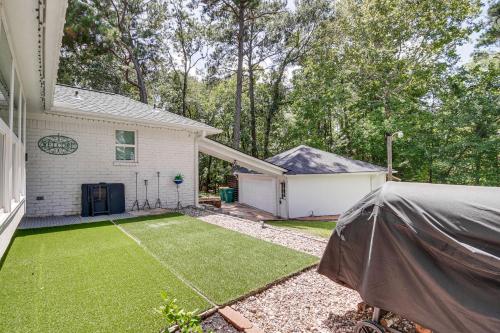 a backyard with a lawn and a house at Quiet Texas Vacation Rental about 5 Mi to Lake Conroe! in Conroe