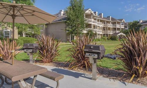 a couple of bbqs and a table with an umbrella at Worldmark Windsor 1BD in Windsor
