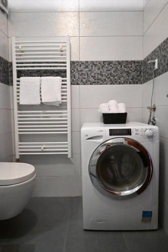 a bathroom with a washing machine and a toilet at Golden Valley in Sarajevo