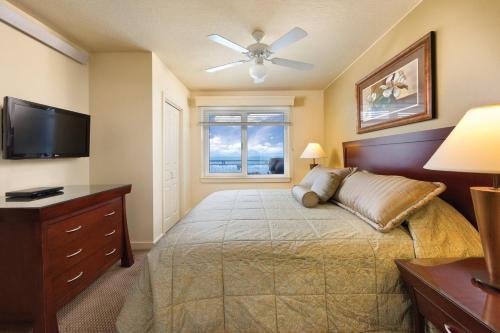a bedroom with a bed and a flat screen tv at Worldmark Seaside Condo 2BD in Seaside