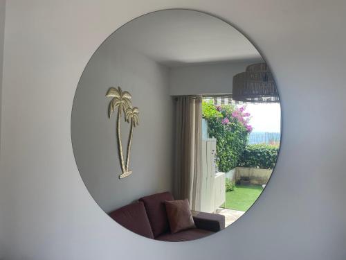 - un miroir dans le salon avec une photo de palmier dans l'établissement La Perle de Lilly, à Menton