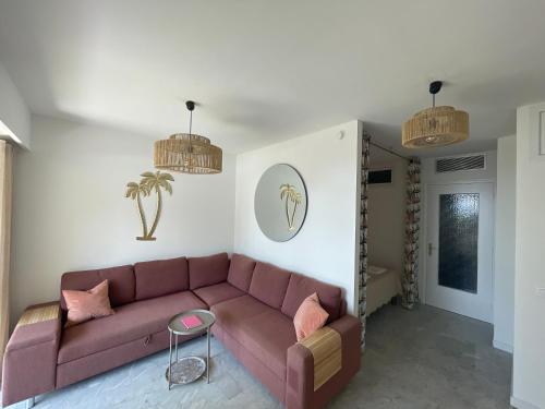 - un salon avec un canapé brun et des oreillers roses dans l'établissement La Perle de Lilly, à Menton