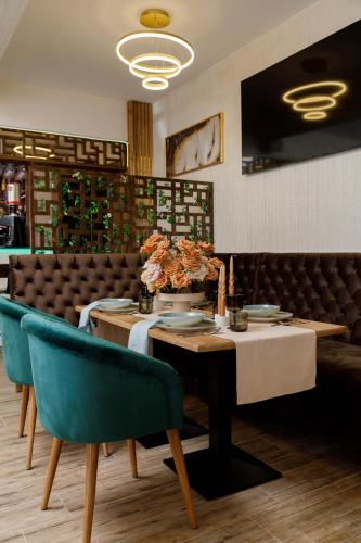 a table and chairs in a restaurant with a table and chairs sidx sidx at Pensiunea Natalya in Bacău