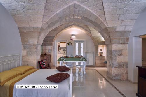 ein Zimmer mit einem Bett und einem Tisch darin in der Unterkunft Mille908 in Muro Leccese