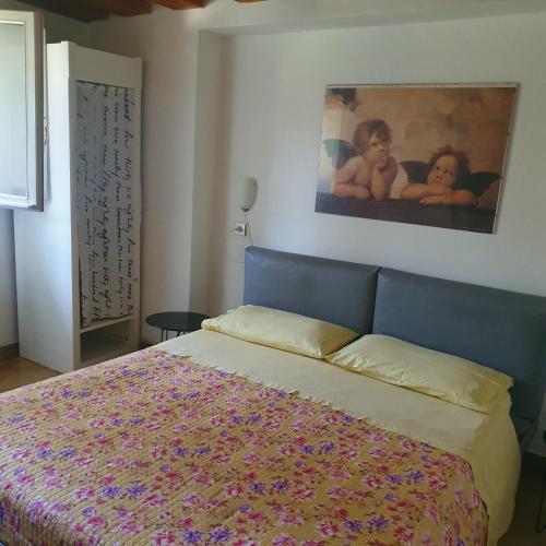 a bedroom with a bed and a painting on the wall at La DOGARESSA in Porto Viro