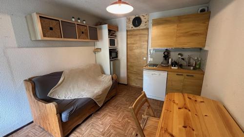 - une petite cuisine avec un lit et une table dans l'établissement Chez Margaux a Colchique, à Sainte-Marie-de-Vars