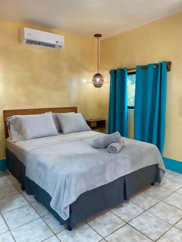 a bedroom with a large bed with blue curtains at Apartments at Los Delfines Little Corn in Little Corn Island