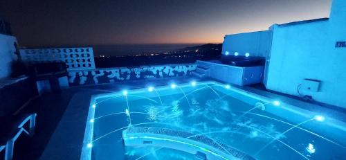 a swimming pool on top of a building at night at ALOELUX VILLA !! - Private Villa with POOL , jacuzzi, cinema, massage ,wonderful view, art desing villa in Tías