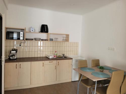 a kitchen with a table and chairs and a microwave at Villa Balifornia in Balatonboglár