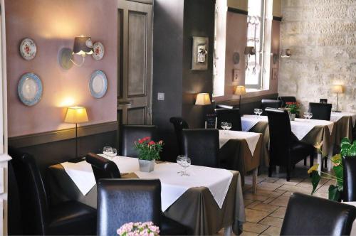 a restaurant with tables and chairs with white tablecloths at Hôtel du Palais des Papes in Avignon