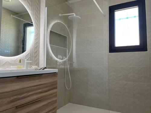 La salle de bains est pourvue d'une douche avec un miroir et un lavabo. dans l'établissement Maison quartier la Campane Narbonne, à Narbonne