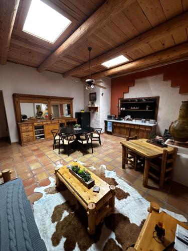 a large living room with tables and a kitchen at Adobe Rose Boutique Inn in Artesia