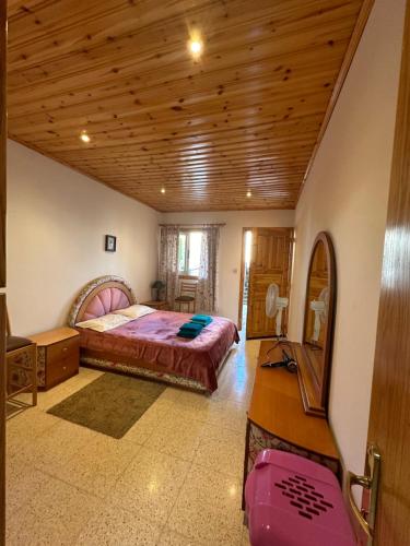 a bedroom with a bed and a wooden ceiling at Koilani Vacation House in Koilani