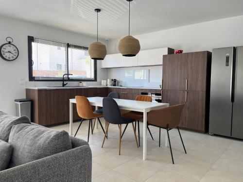 une cuisine et un salon avec une table et des chaises dans l'établissement Maison quartier la Campane Narbonne, à Narbonne
