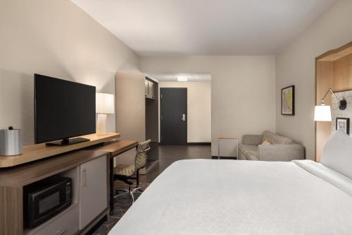 a hotel room with a bed and a flat screen tv at Holiday Inn Cheshire - Southington by IHG in Southington