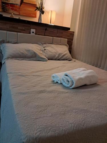 a bed with two towels on top of it at Aconchego Vila Rica - Mariana in Mariana