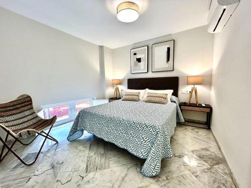 a bedroom with a bed and a chair at Apartamento RIOS ROSAS - RONDA FUSION APARTAMENTOS in Ronda