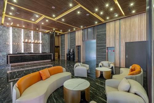 a lobby with couches and tables and a television at OOD Hotel Taipei HangZhou in Taipei