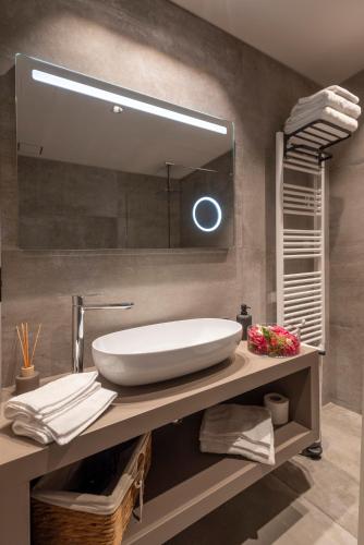 a bathroom with a sink and a large mirror at Relais PQlin in Castagnito