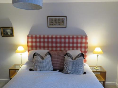 a bed with two pillows on it with two lamps at Abacus Cottage in Whitwell on the hill