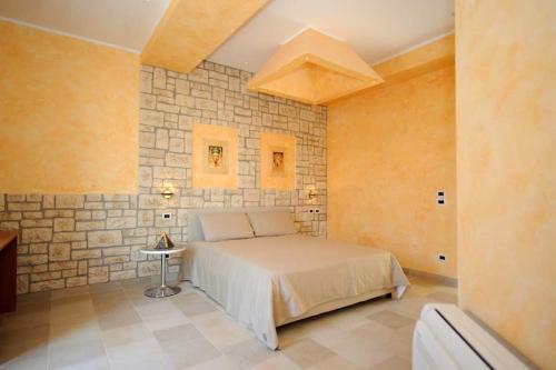 グイドニアにあるVilla Tivoliの石壁のベッドルーム1室(ベッド1台付)