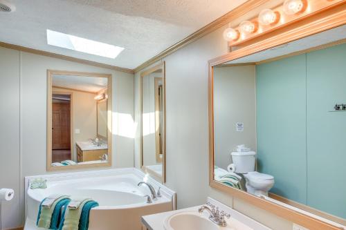 Lyndon StationにあるPeople and Paws Home with Fenced Yard by the Dells!の浴槽、洗面台、鏡のあるバスルーム