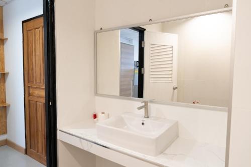 a bathroom with a white sink and a mirror at Chiang Mai Mansion in Chiang Mai