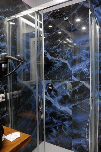 a shower with a glass door in a bathroom at B&B AIDA Rooms Cefalù in Cefalù