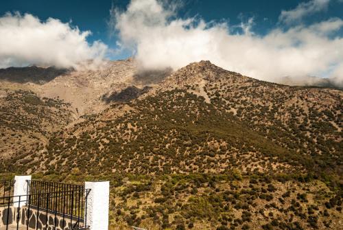 a view of a mountain with clouds in the sky at Hotel La Fragua II in Trevélez