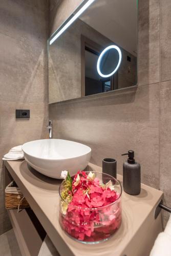 a bathroom with a sink and a bowl of flowers on a counter at Relais PQlin in Castagnito