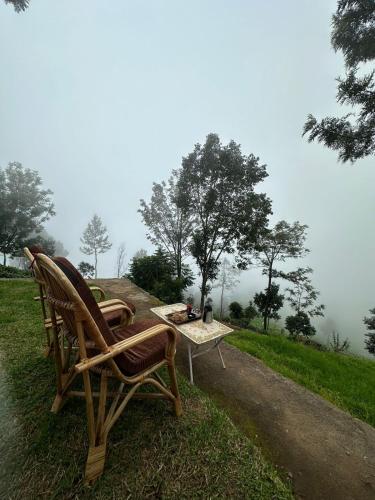 a couple of chairs and a table on a hill at Moksha at Infinity Valley in Kotagiri