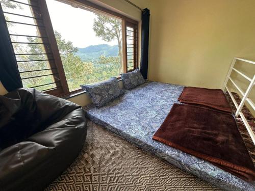 a bedroom with a bed and a large window at Moksha at Infinity Valley in Kotagiri