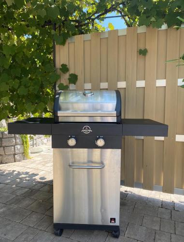a grill on a table in front of a fence at Spacious apartment in nature with sauna! in Postojna