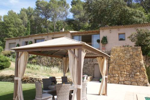 a wooden gazebo in front of a house at L'Irisciabella in Lourmarin