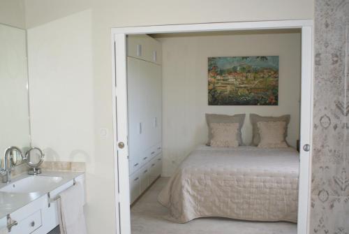 a white bedroom with a bed and a sink at L'Irisciabella in Lourmarin