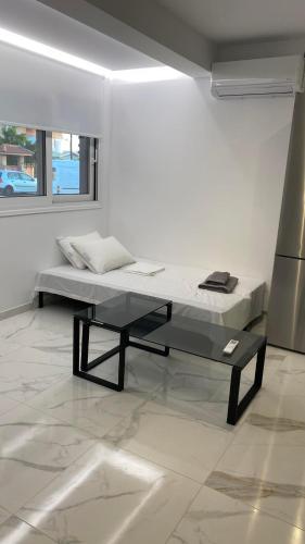 a white room with a bed and a table at Maria's Studio in Kalamata