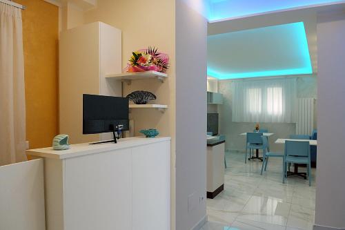 a living room with a television on a white counter at B&B AIDA Rooms Cefalù in Cefalù