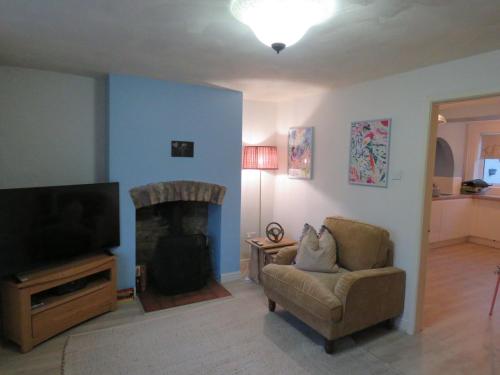 a living room with a couch and a television at Abacus Cottage in Whitwell on the hill