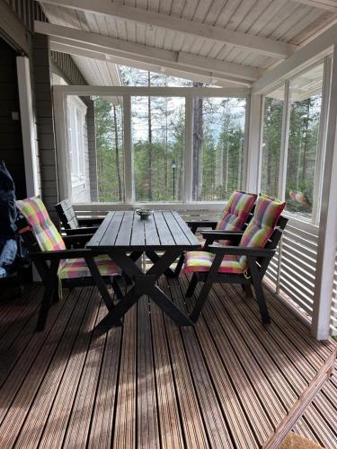 a screened in porch with a wooden table and chairs at Villa Porotupa in Syöte
