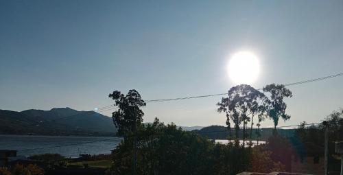 a sun setting over a body of water with trees at Bellavista Casa de Huéspedes in San Pablo