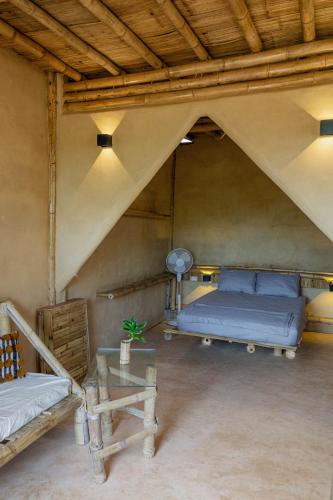 a attic bedroom with two beds and a table at Bambú Corner - Casa Consciente in Brisas de Zicatela
