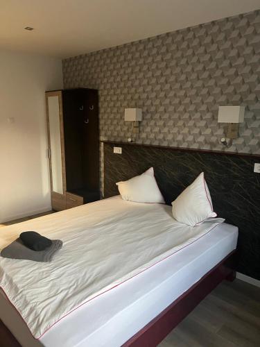 a bedroom with a large white bed with two pillows at Vila Phoenix in Călimăneşti