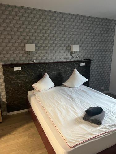 a bed with two pillows and a hat on it at Vila Phoenix in Călimăneşti